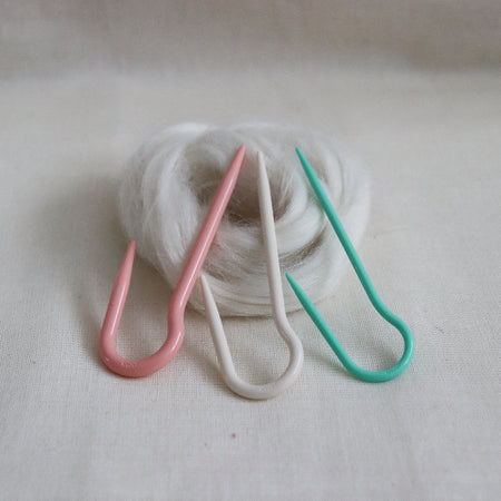 clover u shaped cable needles in pink, cream and mint.