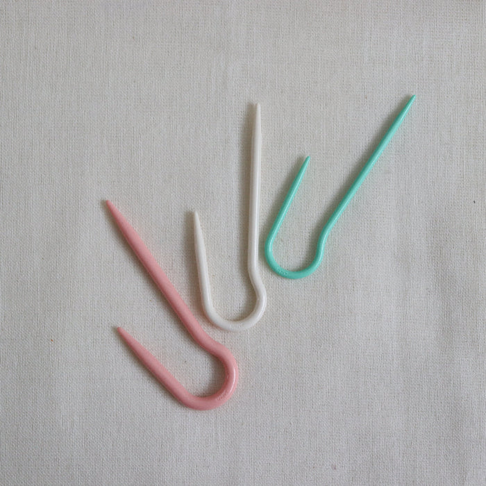 clover u shaped cable needles in pink, cream and mint.