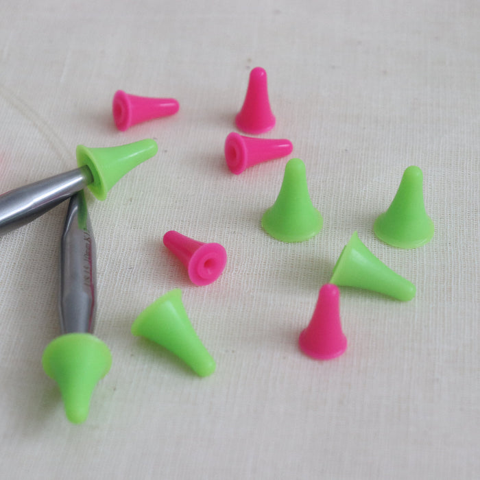 pink and green hiyahiya point protectors on some metal hiyahiya circular knitting needles.