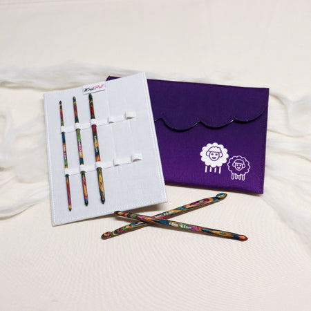 Knitpro symfonie multicoloured layered wood crochet hooks in white sleeve with elastic loops with a purple cloth case.