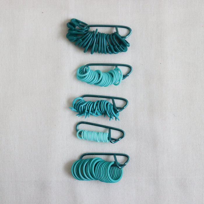 knitpro mindful collection teal stitch markers in 5 different shapes and styles.