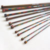 Symfonie single point straight knitting needles, made from multicoloured layered and laminated wood with sizes printed on the needles.