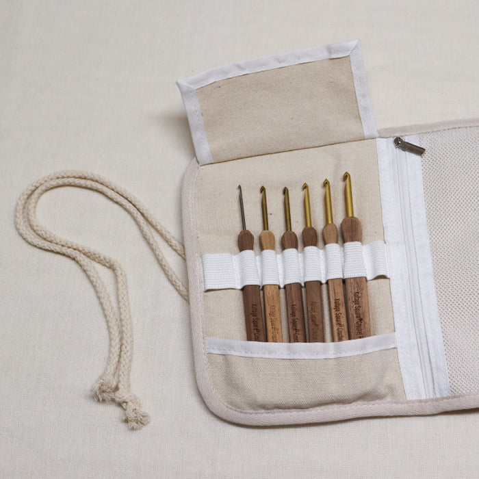 kollage square crochet hook set. Aluminium crochet hooks with a wooden handle in a black and white soft cloth pouch with elastic slots for hooks and zipped pouch.